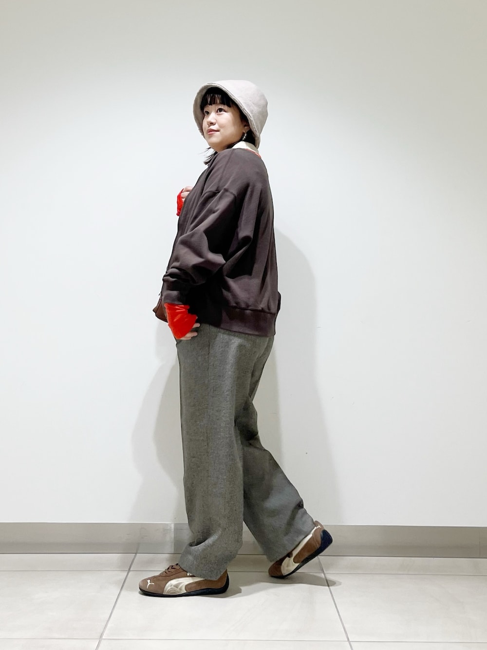 レッド系のニット/セーター、グレー系のその他パンツ、ブラック系のスニーカーを着用したレディースの秋コーディネートの9枚目の写真