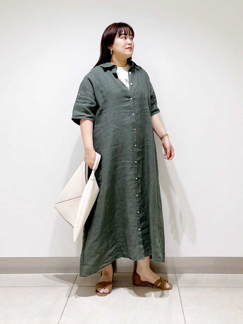 グリーン系のワンピース、ホワイト系のトートバッグ、ベージュ系のサンダルを着用したレディースの春コーディネートの7枚目の写真