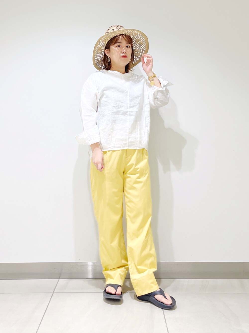 ホワイト系のシャツ/ブラウス、イエロー系のその他パンツ、ブラック系のサンダルを着用したレディースの春コーディネートの2枚目の写真