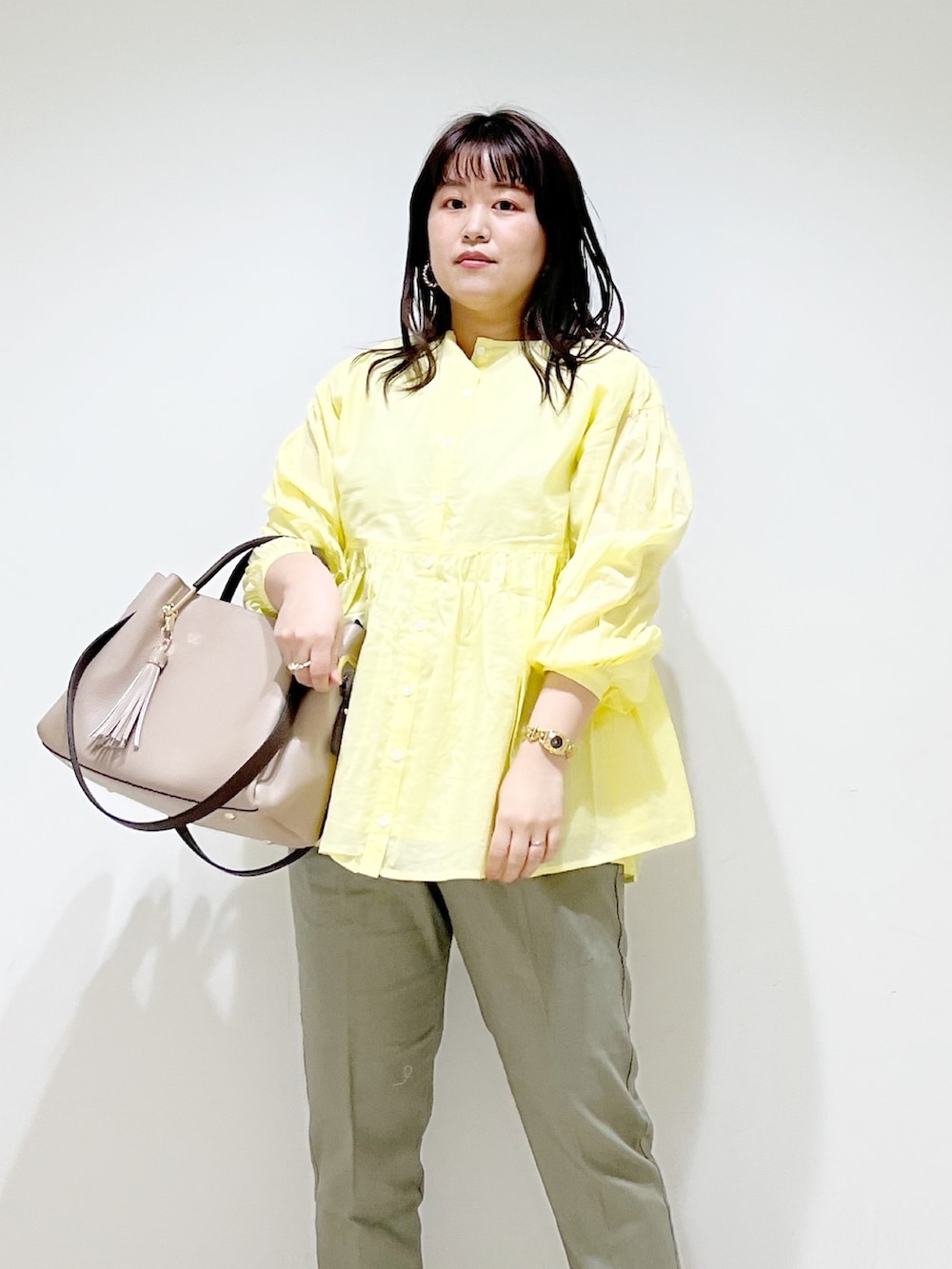 イエロー系のシャツ/ブラウス、グリーン系のその他パンツ、ベージュ系のトートバッグを着用したレディースの春コーディネートの5枚目の写真
