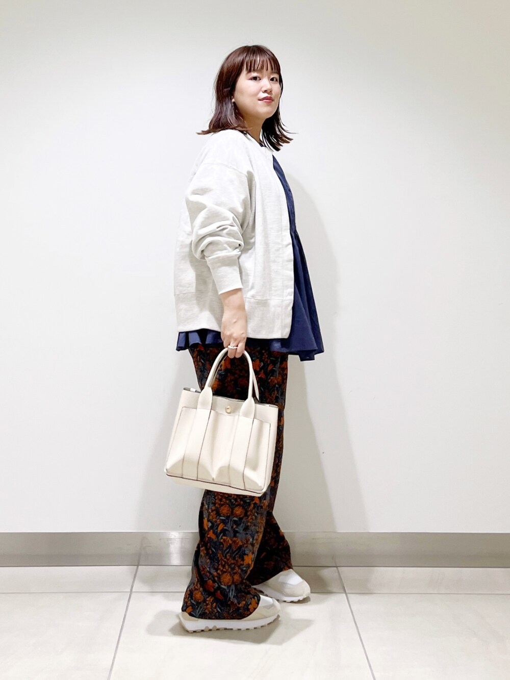 グレー系のカーディガン/ボレロ、ブルー系のシャツ/ブラウス、グレー系のトートバッグを着用したレディースの秋コーディネートの8枚目の写真