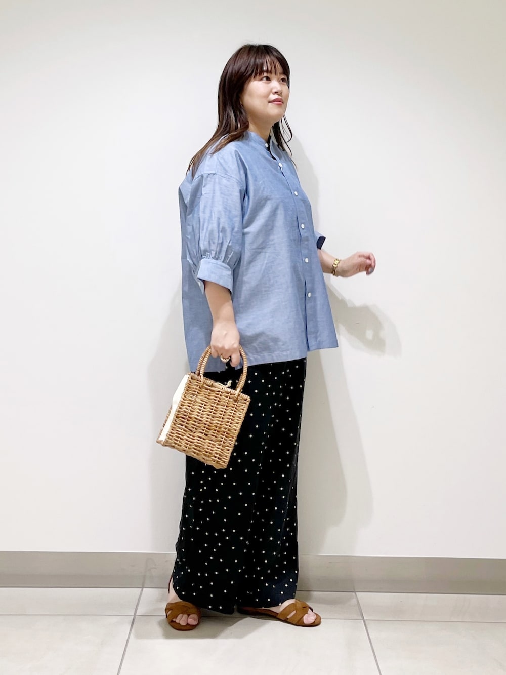 ブルー系のシャツ/ブラウス、ブラック系のその他パンツ、ベージュ系のハンドバッグを着用したレディースの夏コーディネートの3枚目の写真