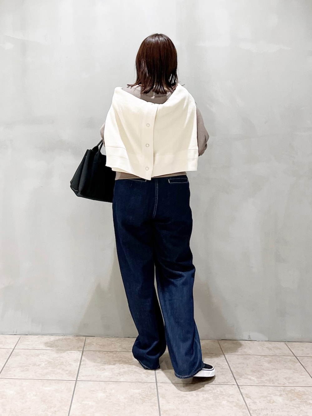 グレー系のTシャツ/カットソー、ホワイト系のカーディガン/ボレロ、ブラック系のトートバッグを着用したレディースの秋コーディネートの7枚目の写真