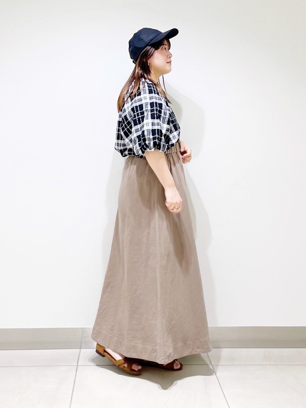 ベージュ系のスカート、ベージュ系のサンダル、ブラック系のシャツ/ブラウスを着用したレディースの夏コーディネートの4枚目の写真