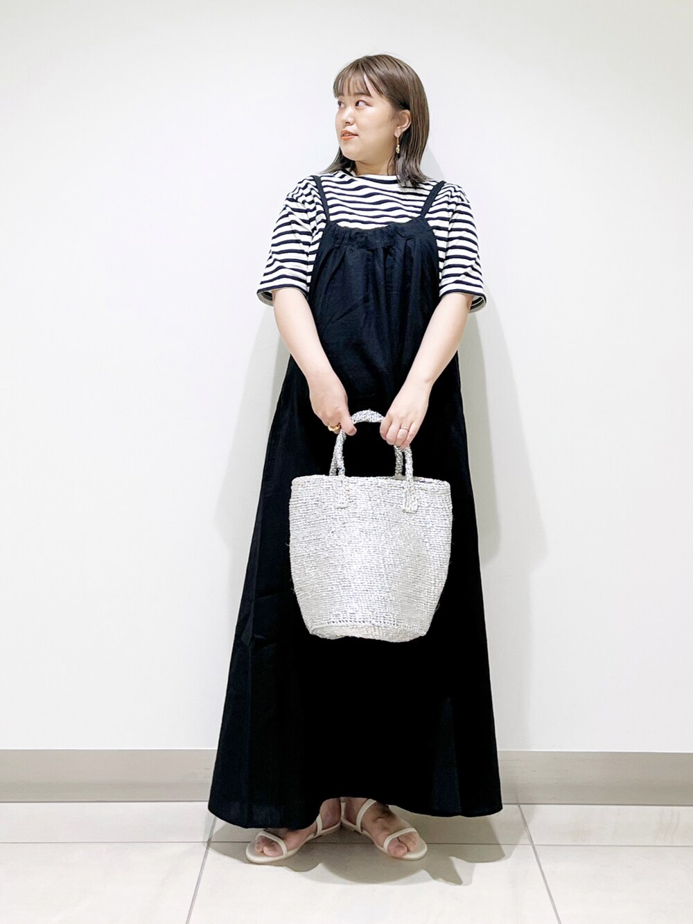 ブラック系のTシャツ/カットソー、ブラック系のワンピース、シルバー系のトートバッグを着用したレディースの春コーディネートの5枚目の写真