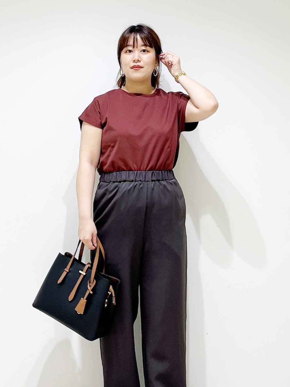 レッド系のTシャツ/カットソー、グレー系のその他パンツ、ブラック系のトートバッグを着用したレディースの夏コーディネートの5枚目の写真