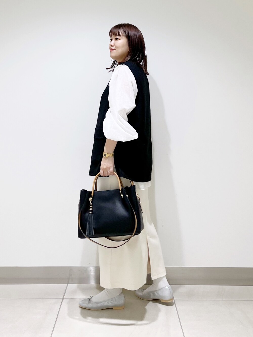 ブラック系のトップス、ホワイト系のシャツ/ブラウス、その他のスカートを着用したレディースの秋コーディネートの10枚目の写真