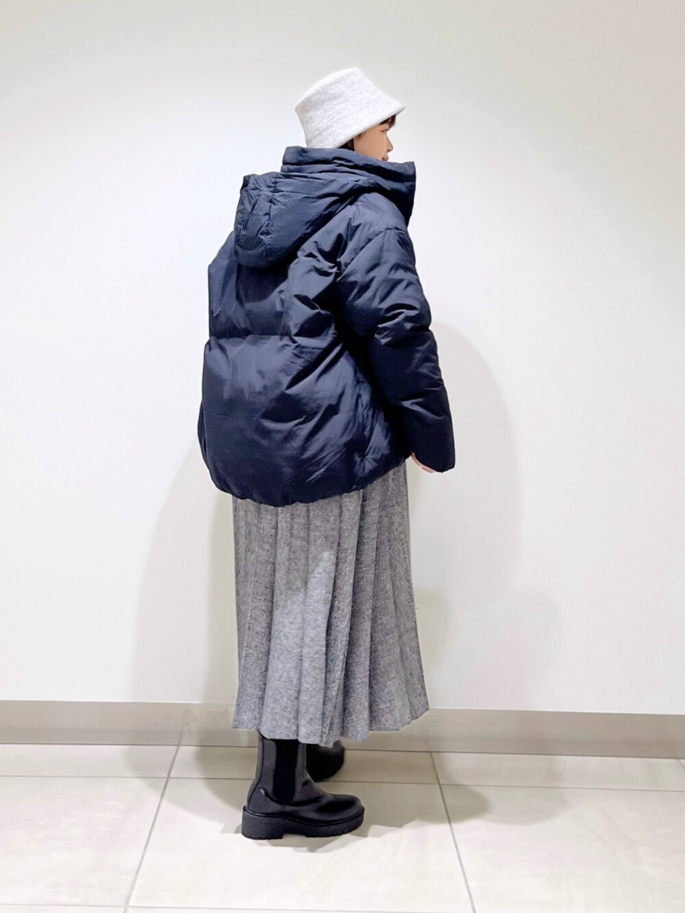 ブラック系のダウンジャケット/コート、ピンク系のニット/セーター、ブルー系のスカートを着用したレディースの冬コーディネートの5枚目の写真