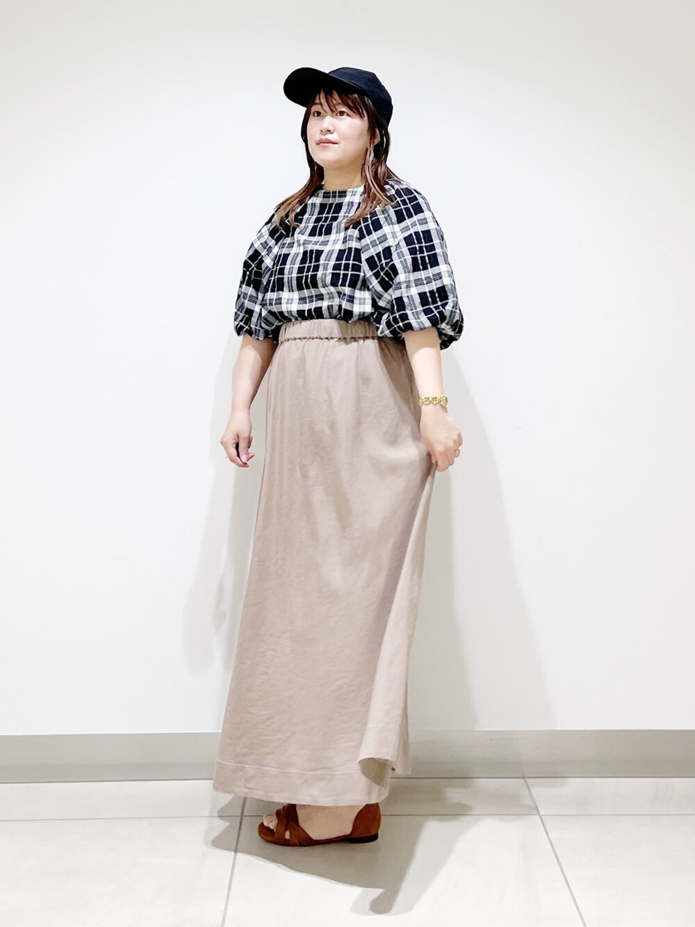 ベージュ系のスカート、ベージュ系のサンダル、ブラック系のシャツ/ブラウスを着用したレディースの夏コーディネートの6枚目の写真