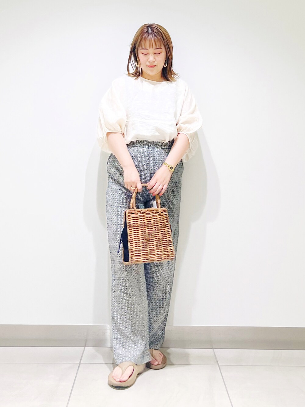 ブラック系のハンドバッグ、グリーン系のその他パンツ、ベージュ系のシャツ/ブラウスを着用したレディースの夏コーディネートの5枚目の写真