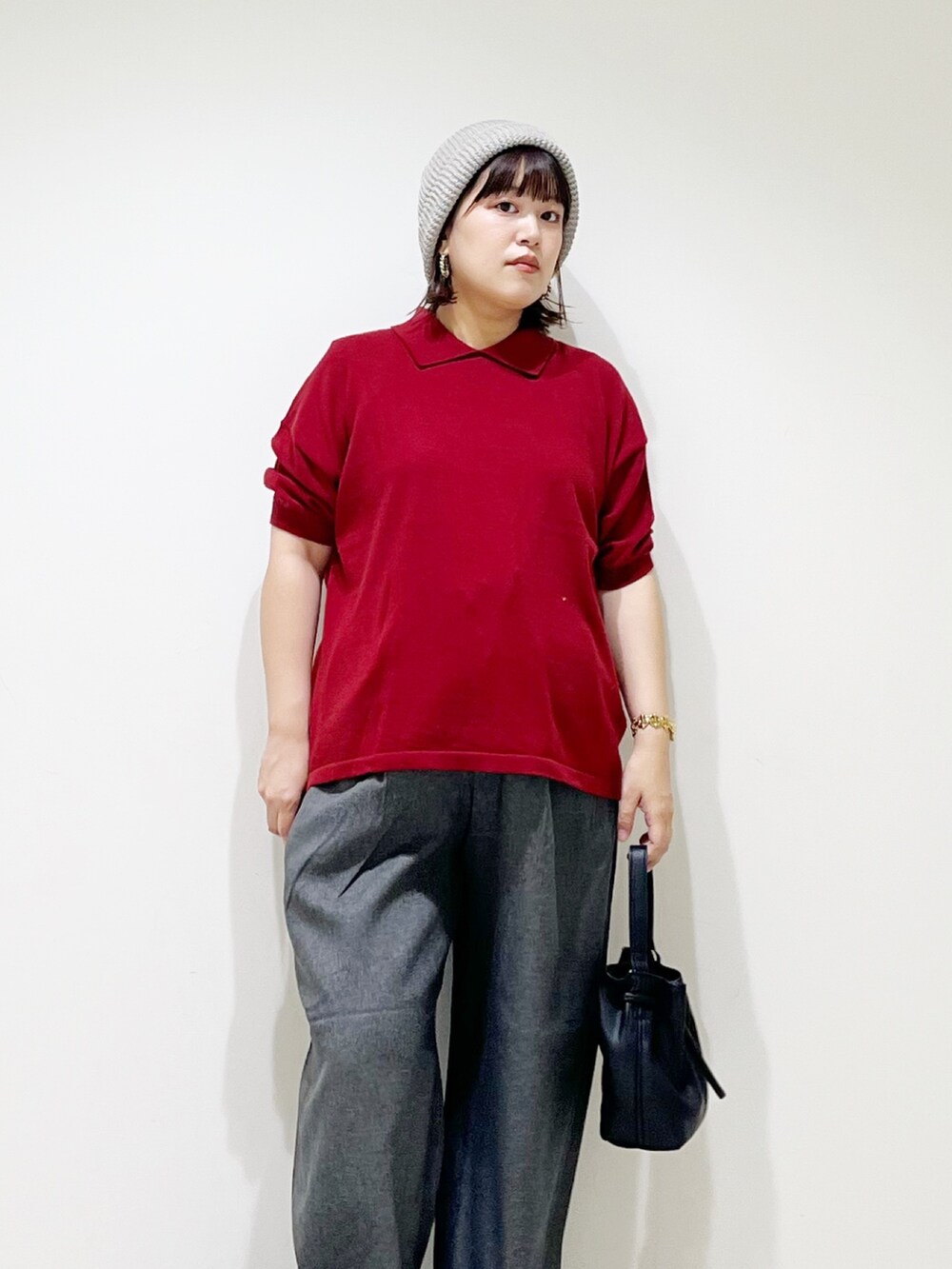 レッド系のニット/セーター、ブラック系のショルダーバッグ、グレー系のその他パンツを着用したレディースの秋コーディネートの3枚目の写真