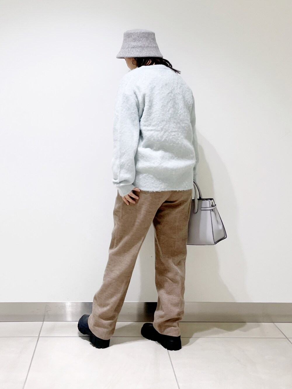 グリーン系のカーディガン/ボレロ、ベージュ系のその他パンツ、ブラック系のブーツを着用したレディースの秋コーディネートの3枚目の写真