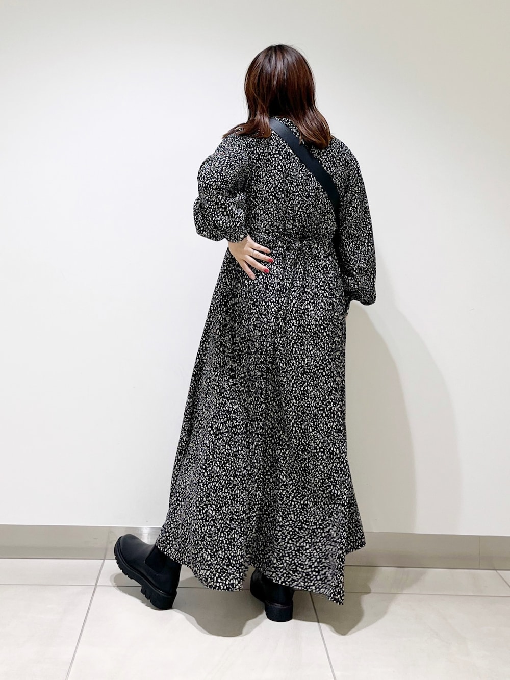 ブラック系のシャツワンピース、ブラック系のショルダーバッグ、ブラック系のブーツを着用したレディースの秋コーディネートの3枚目の写真