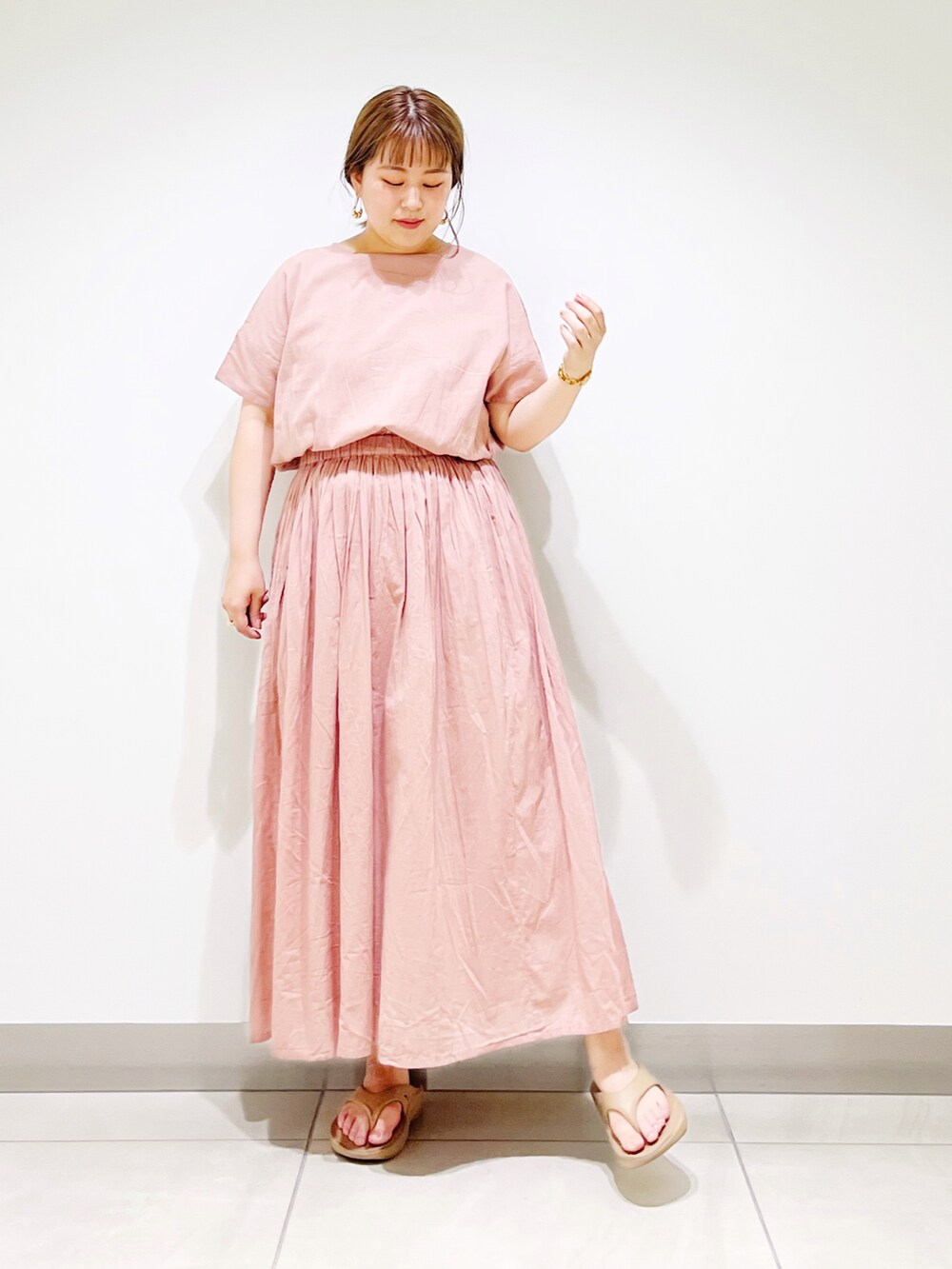 ピンク系のワンピース、ベージュ系のサンダルを着用したレディースの夏コーディネートの2枚目の写真