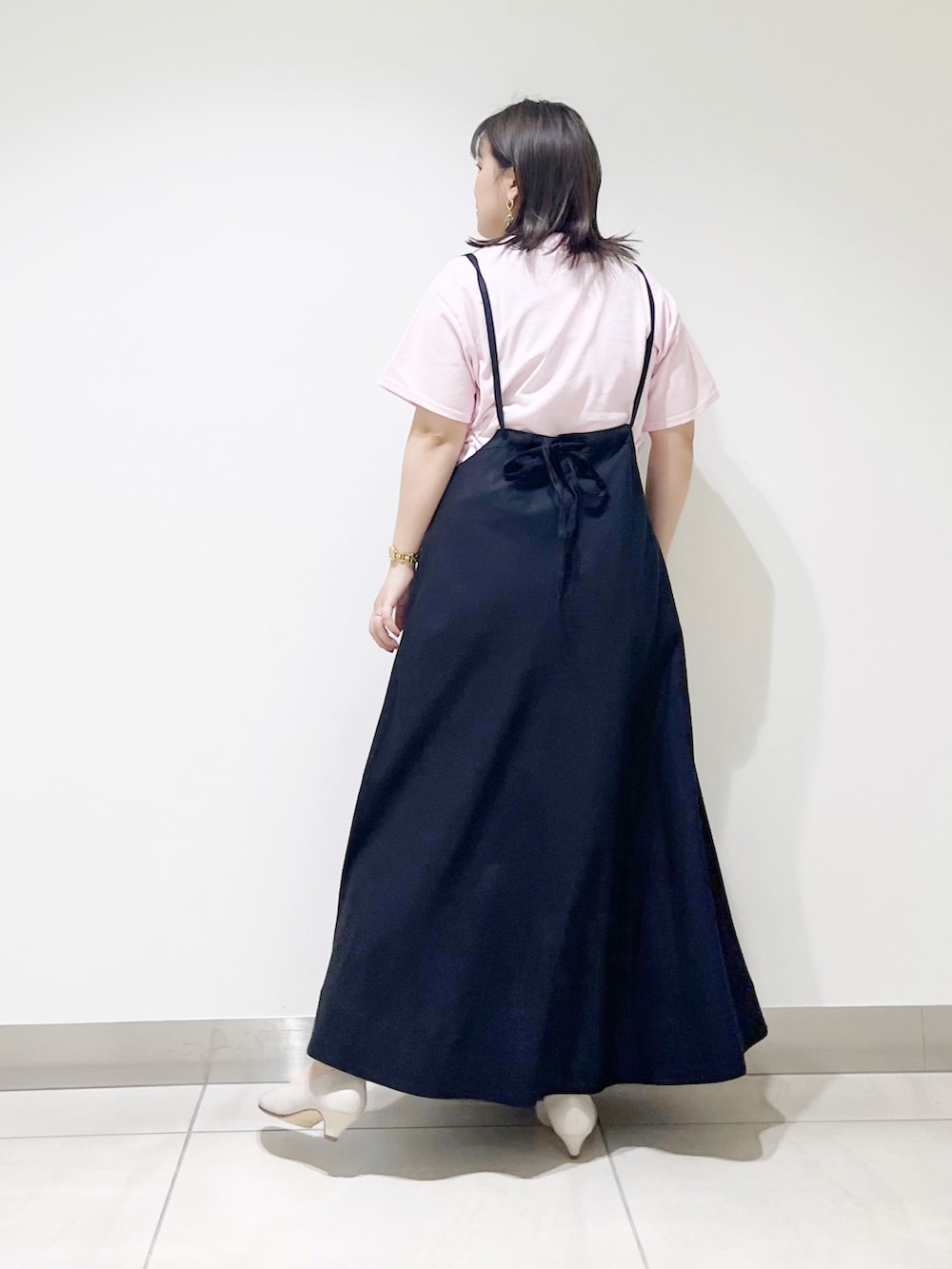 ピンク系のTシャツ/カットソー、ブラック系のスカート、ベージュ系のパンプスを着用したレディースの夏コーディネートの4枚目の写真