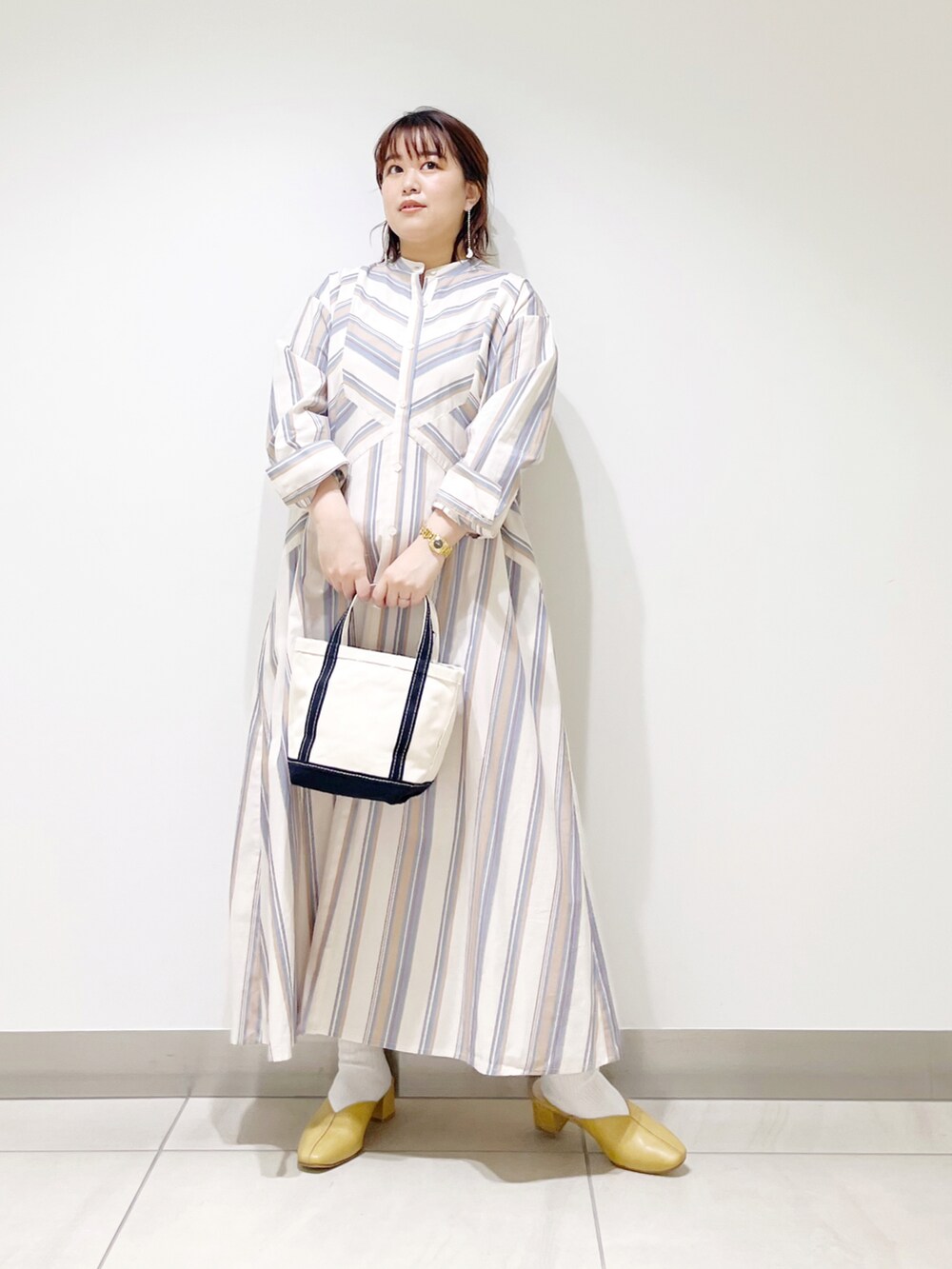 ベージュ系のワンピース、ブルー系のトートバッグ、イエロー系のその他シューズを着用したレディースの春コーディネートの5枚目の写真