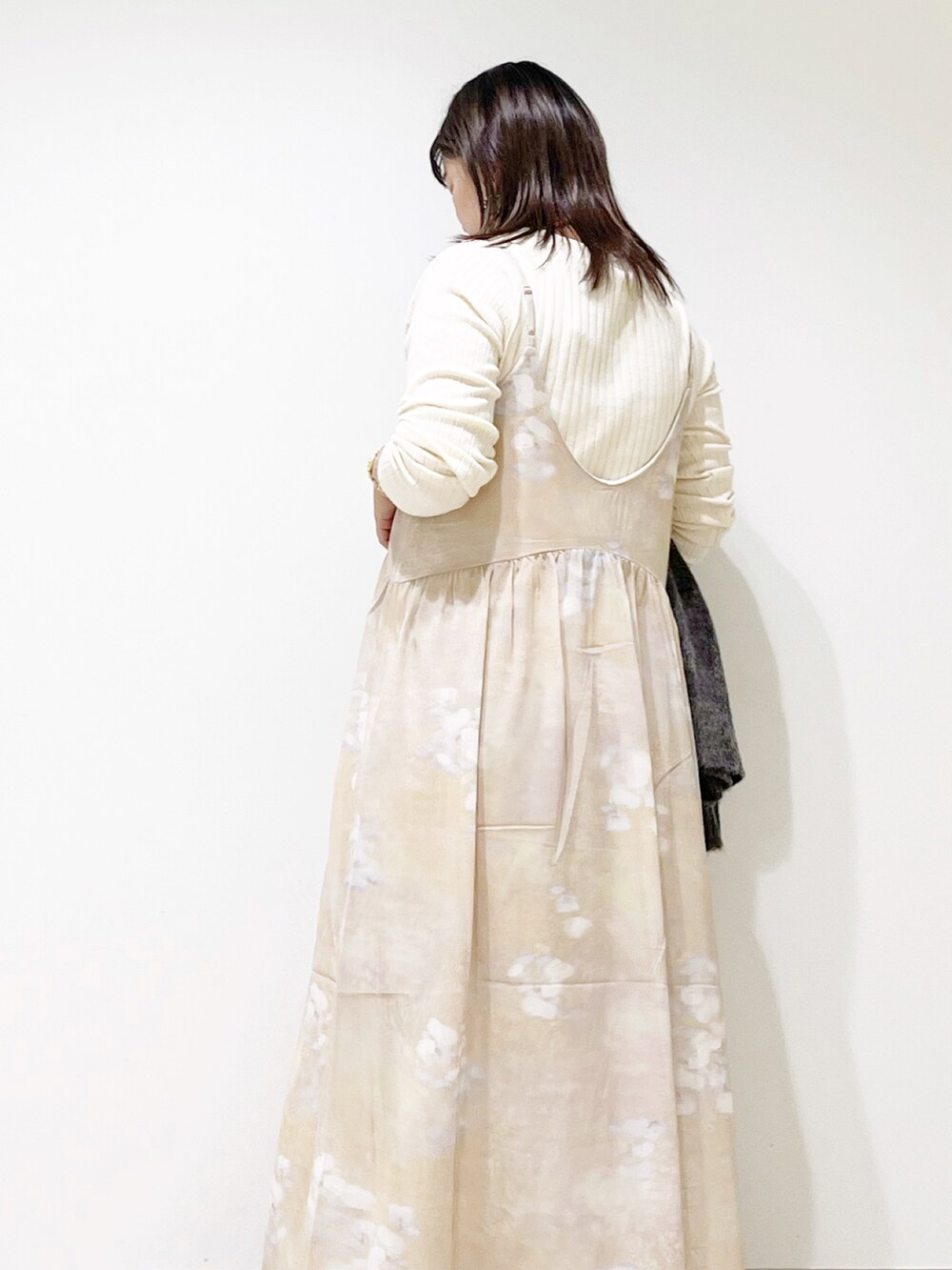 ベージュ系のワンピース、ホワイト系のトートバッグ、ホワイト系のニット/セーターを着用したレディースの秋コーディネートの4枚目の写真