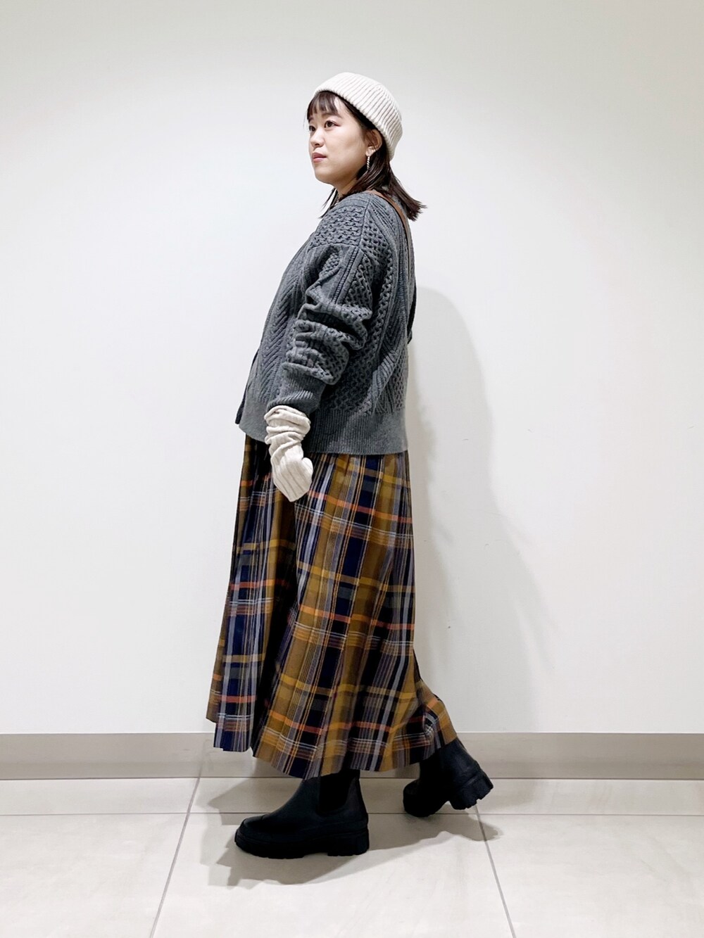 グレー系のカーディガン/ボレロ、ブルー系のスカート、ブラック系のショルダーバッグを着用したレディースの冬コーディネートの4枚目の写真