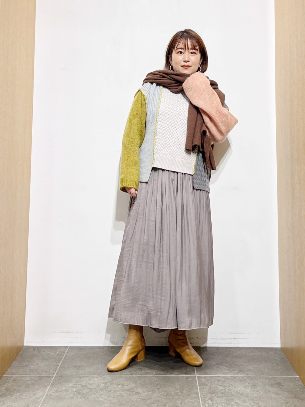 イエロー系のニット/セーター、グレー系のその他パンツ、イエロー系のブーツを着用したレディースの秋コーディネートの3枚目の写真