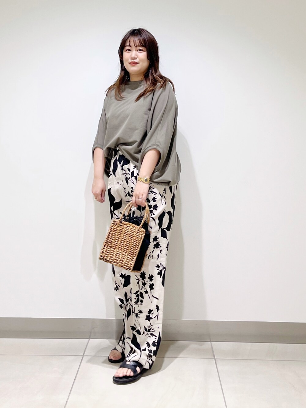 グリーン系のTシャツ/カットソー、ベージュ系のその他パンツ、ブラック系のハンドバッグを着用したレディースの春コーディネートの2枚目の写真