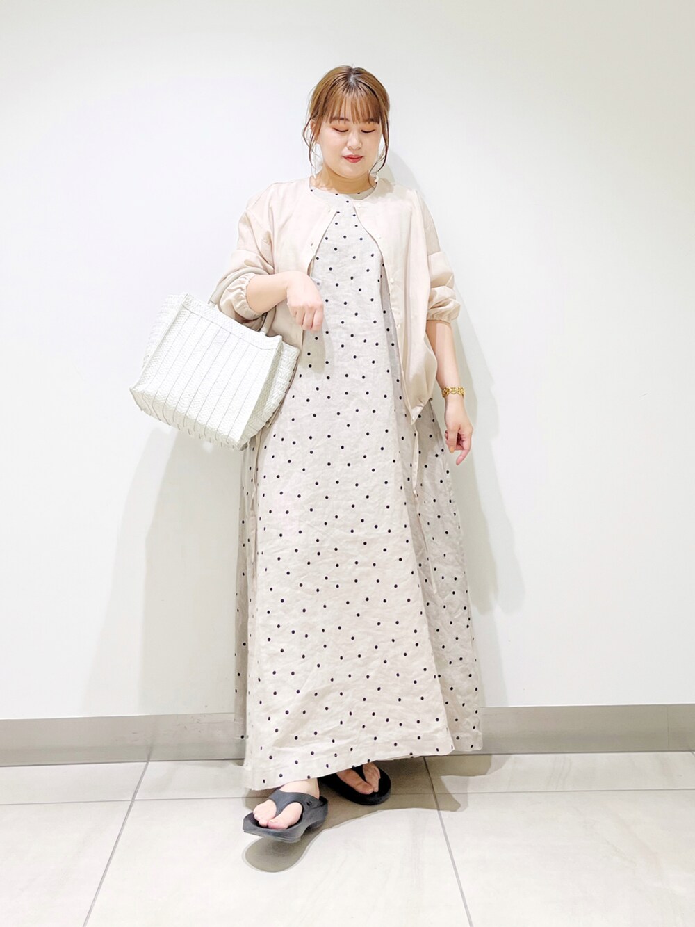 ベージュ系のカーディガン/ボレロ、ベージュ系のワンピース、ホワイト系のトートバッグを着用したレディースの春コーディネートの4枚目の写真