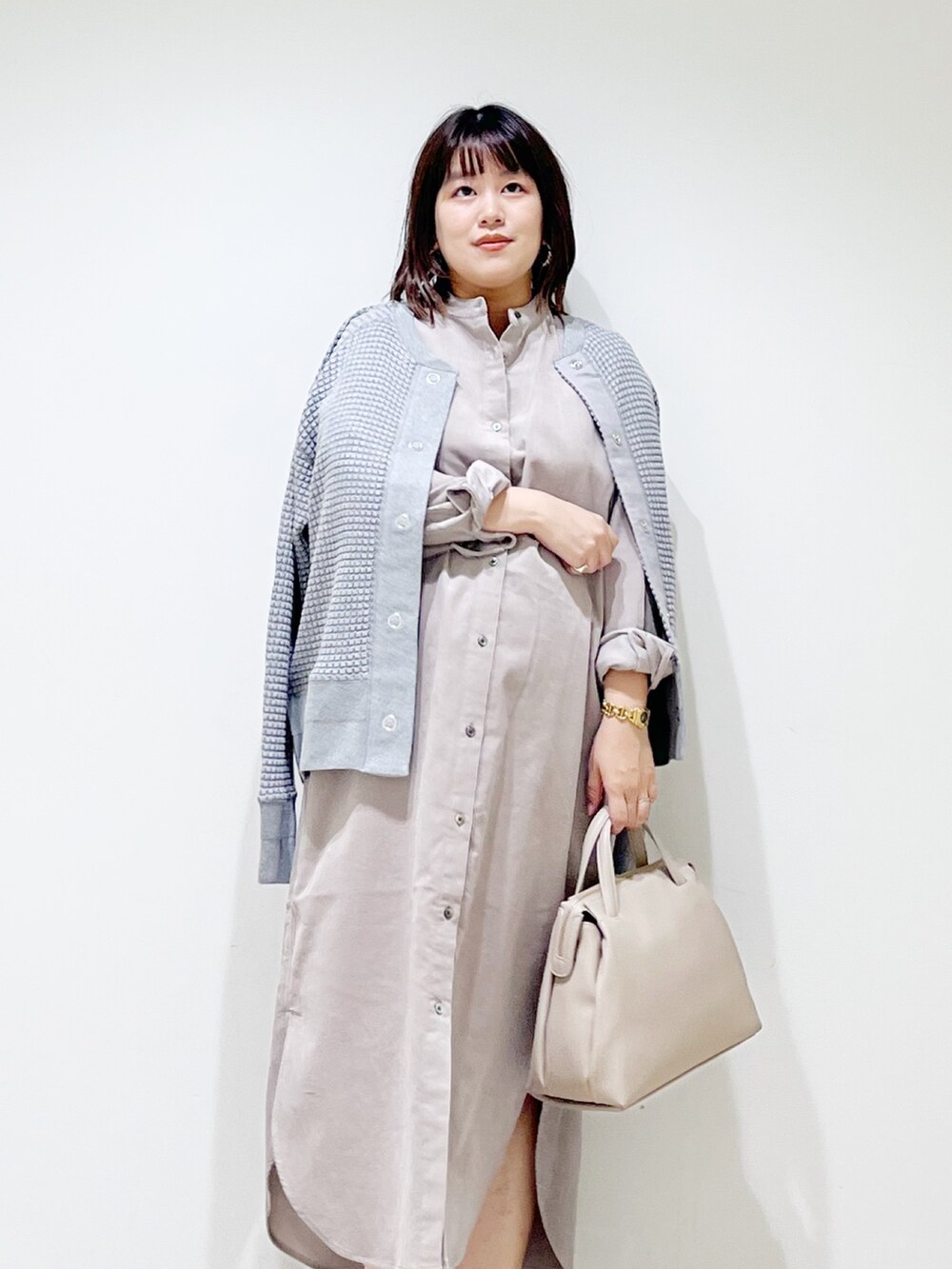 ベージュ系のワンピース、グレー系のカーディガン/ボレロ、グレー系のボストンバッグを着用したレディースの秋コーディネートの6枚目の写真