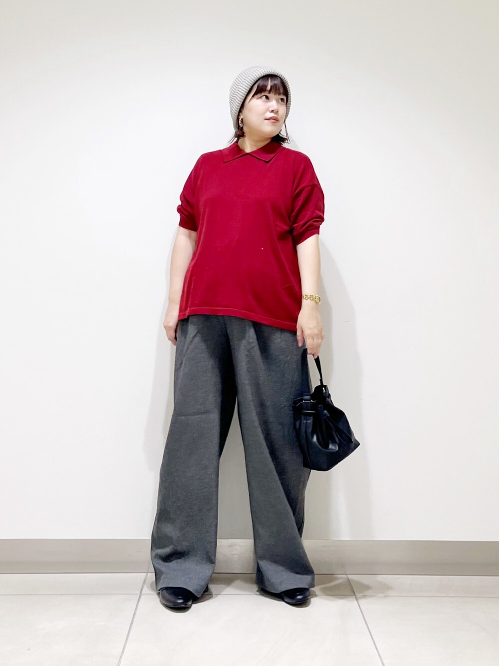 レッド系のニット/セーター、ブラック系のショルダーバッグ、グレー系のその他パンツを着用したレディースの秋コーディネートの7枚目の写真