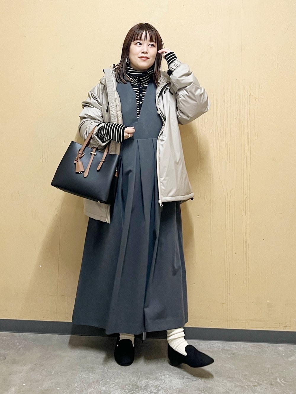 ベージュ系のダウンジャケット/コート、ブラック系のニット/セーター、グレー系のワンピース/ドレスを着用したレディースの秋コーディネートの2枚目の写真