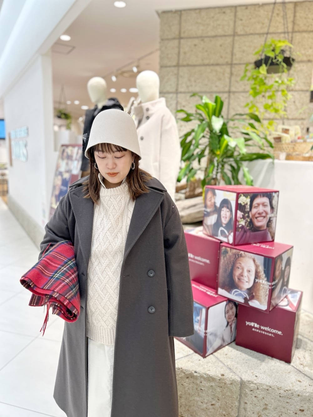 グレー系のチェスターコート、ホワイト系のワンピース、ベージュ系のニット/セーターを着用したレディースの冬コーディネートの7枚目の写真