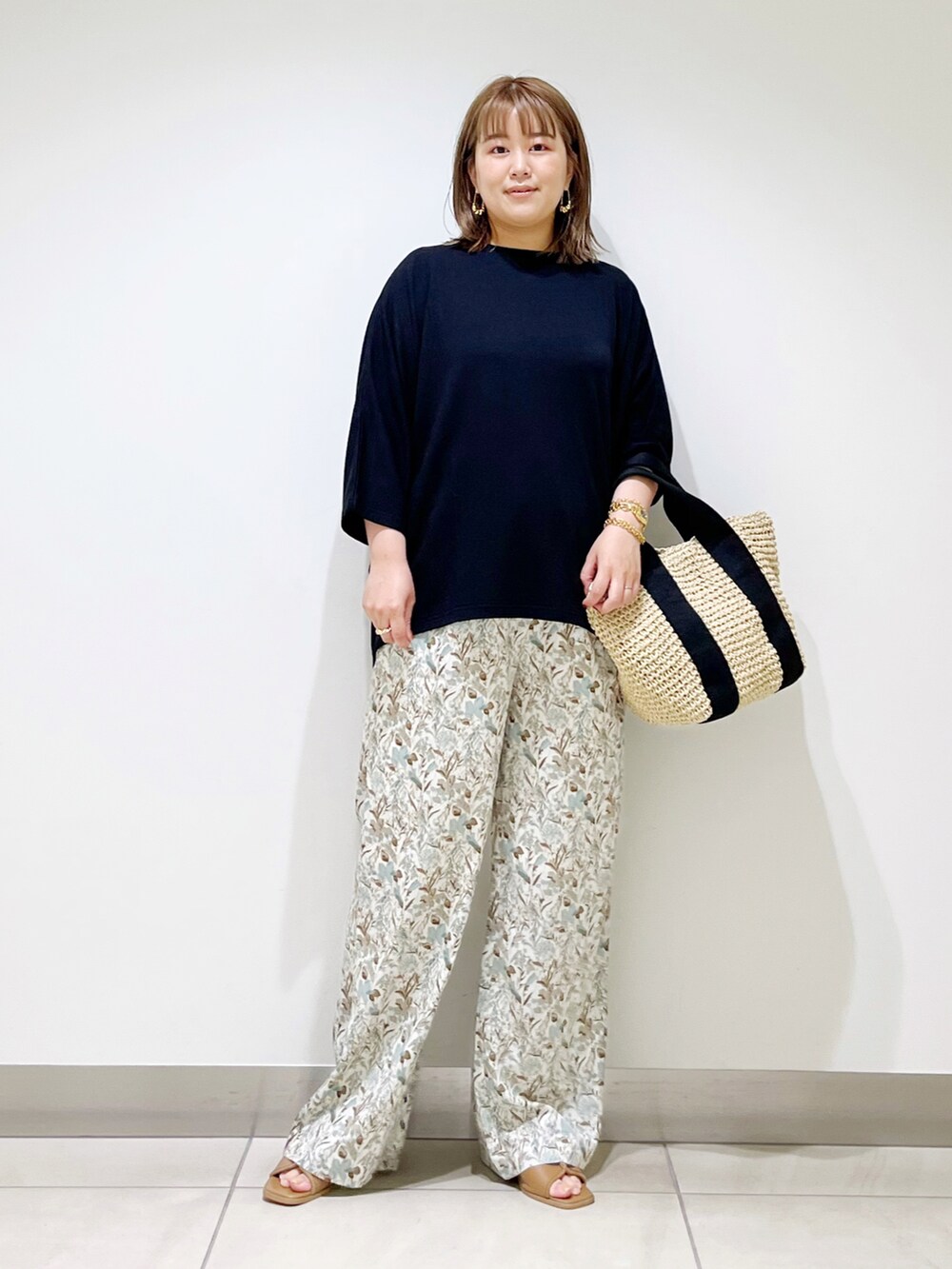 ホワイト系のその他パンツ、ベージュ系のトートバッグ、ブラック系のTシャツ/カットソーを着用したレディースの春コーディネートの2枚目の写真