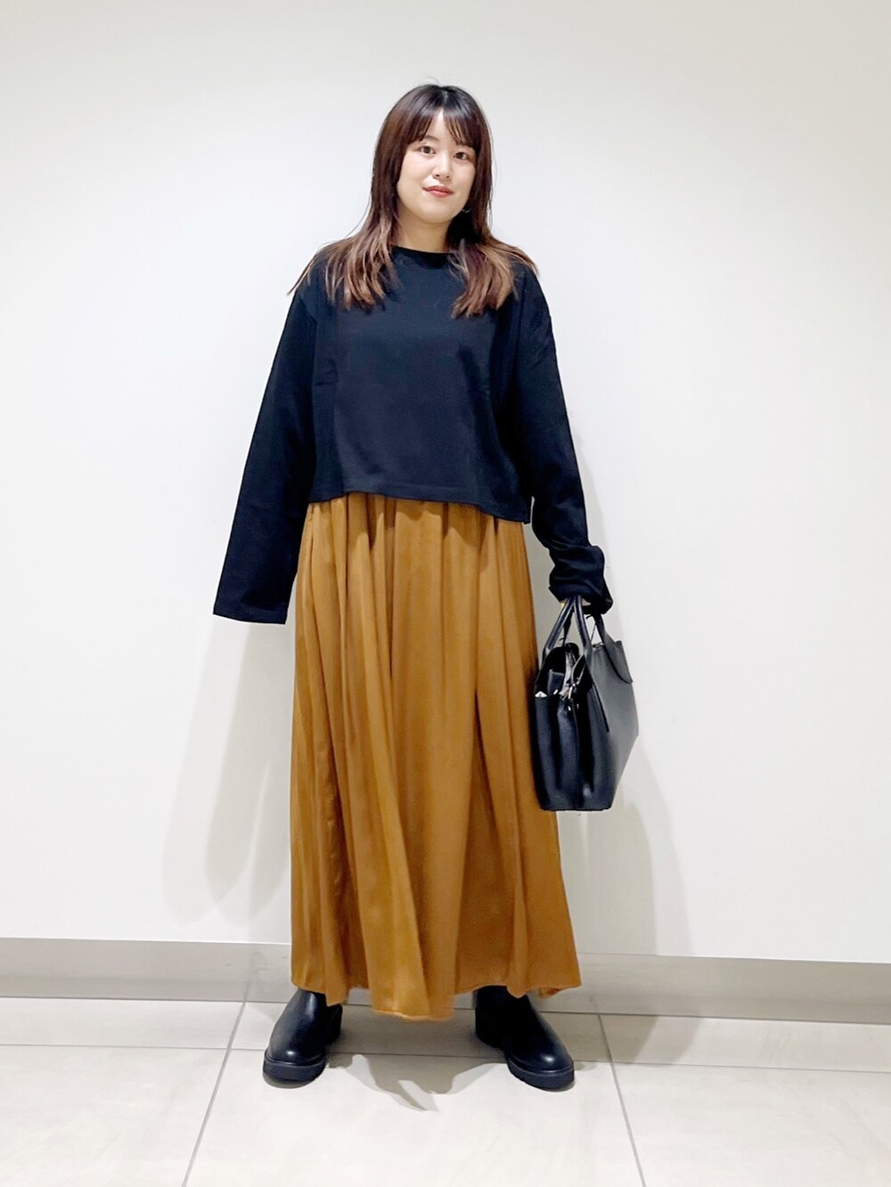 ブラック系のTシャツ/カットソー、イエロー系のパンツ、ブラック系のハンドバッグを着用したレディースの夏コーディネートの3枚目の写真