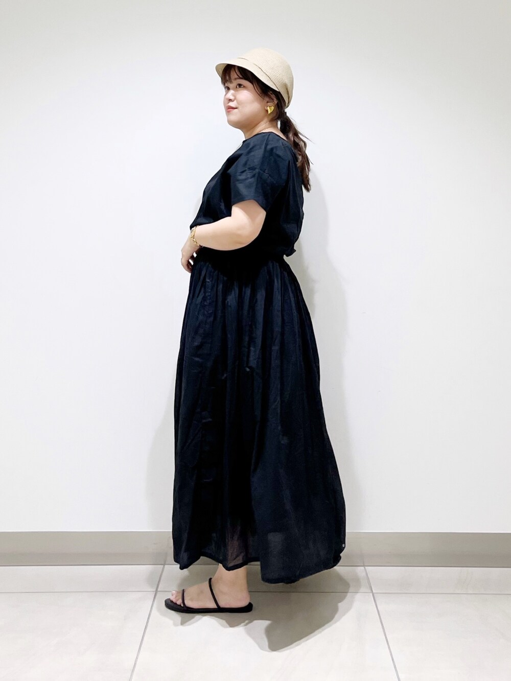 ブラック系のワンピース、ブラック系のサンダル、ベージュ系のキャスケットを着用したレディースの夏コーディネートの6枚目の写真