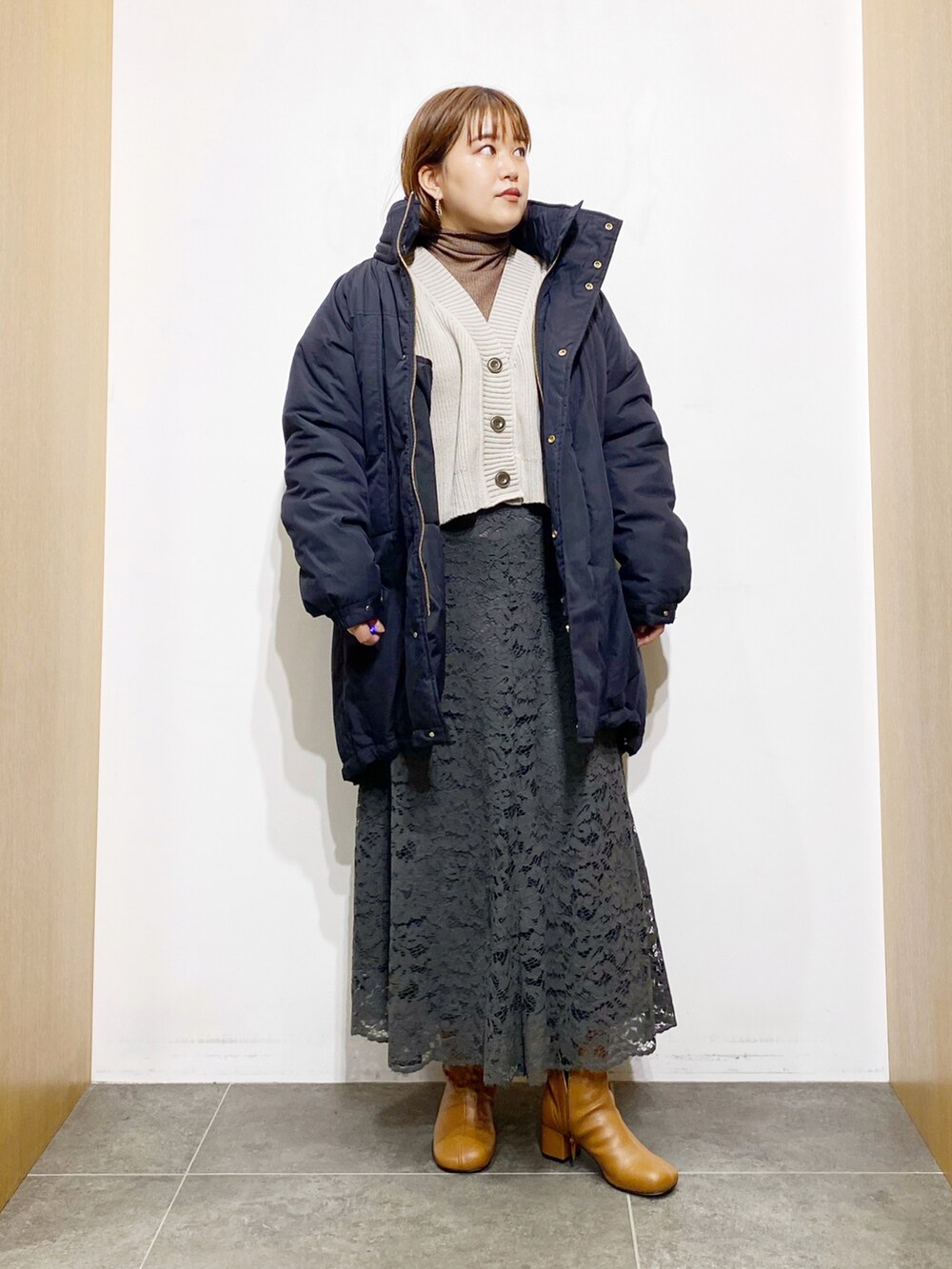 ブラック系のダウンジャケット/コート、ホワイト系のカーディガン/ボレロ、ブラウン系のTシャツ/カットソーを着用したレディースの秋コーディネートの2枚目の写真