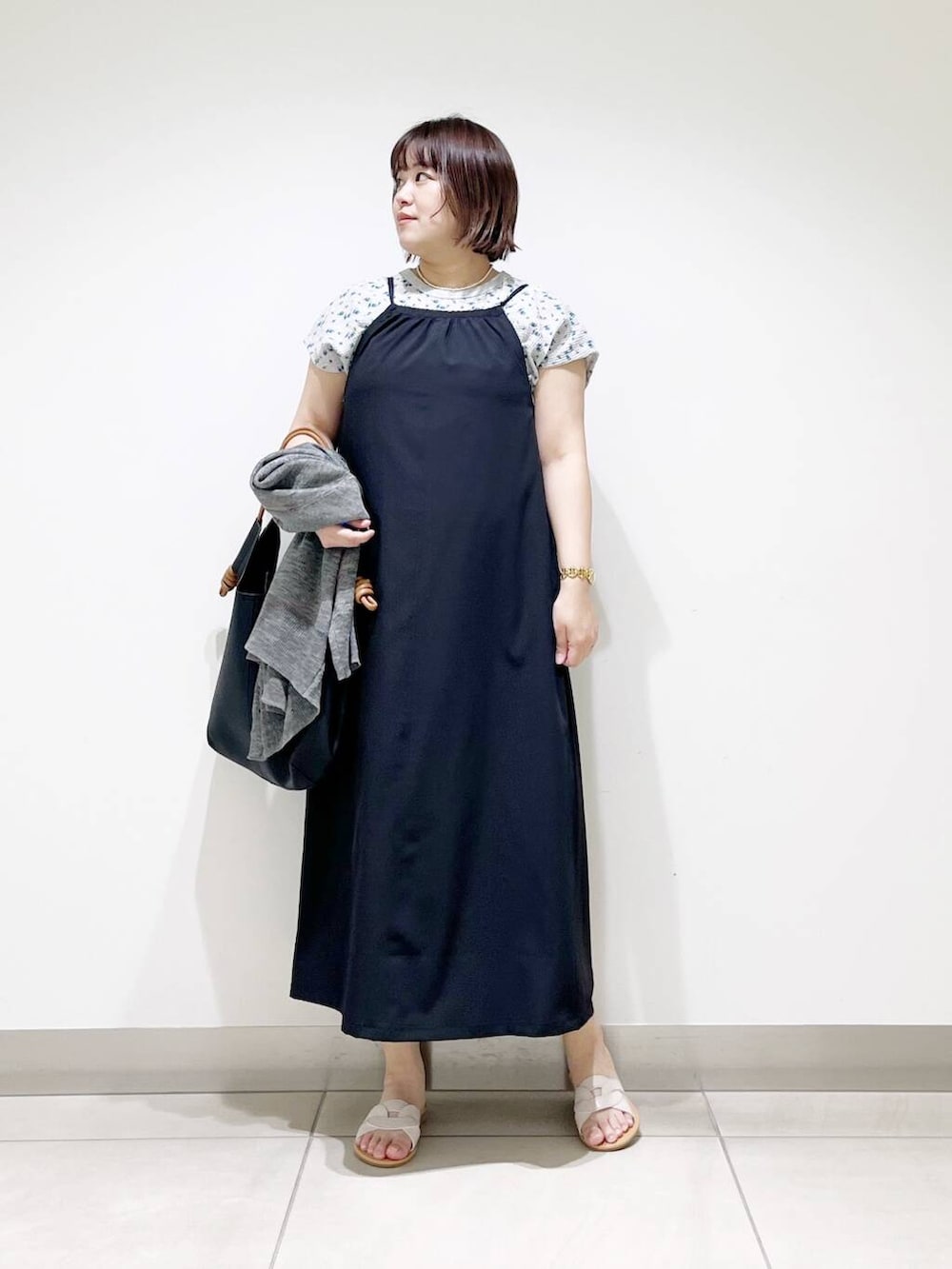 ブラック系のトートバッグ、グレー系のカーディガン/ボレロ、ホワイト系のサンダルを着用したレディースの春コーディネートの7枚目の写真