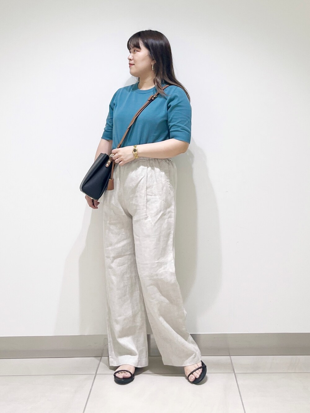 ブルー系のニット/セーター、ベージュ系のその他パンツ、ブラック系のショルダーバッグを着用したレディースの春コーディネートの2枚目の写真