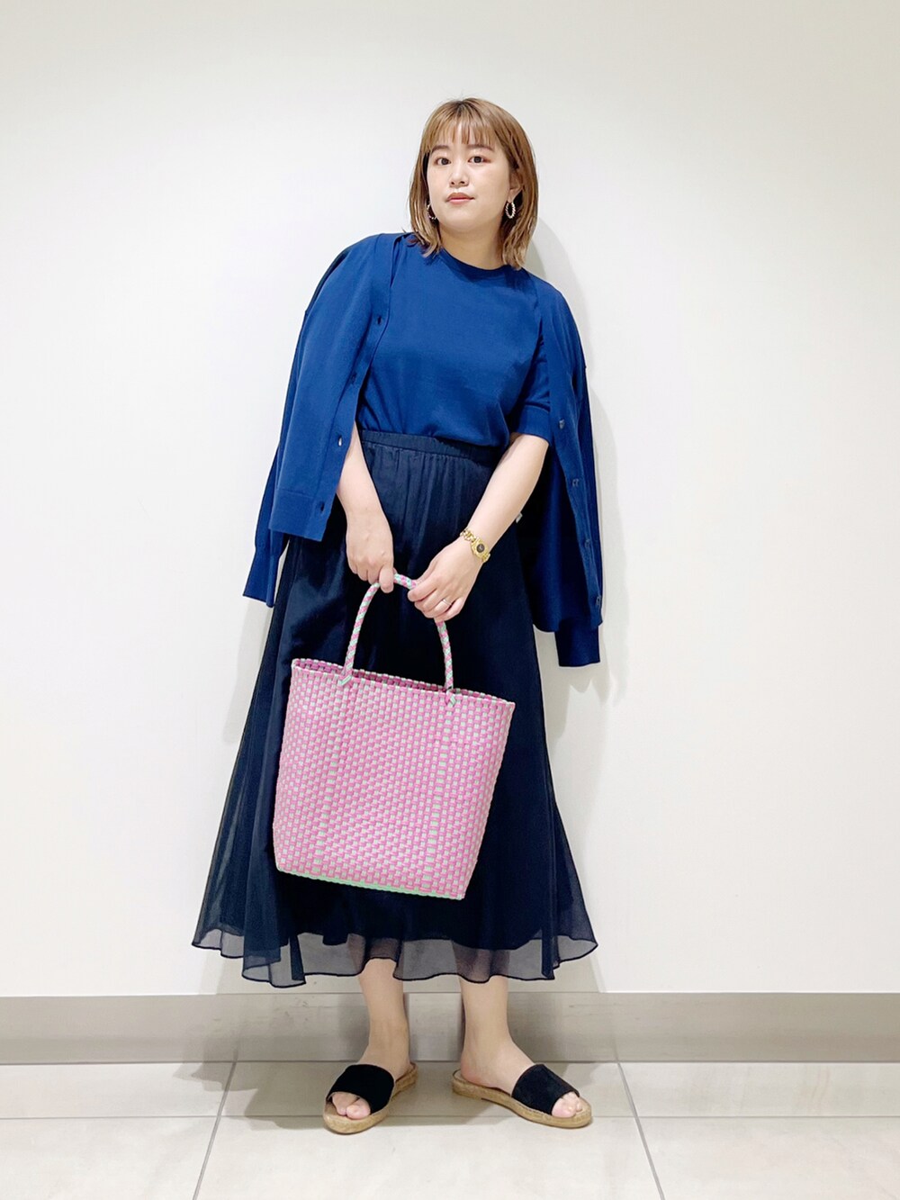 ブルー系のニット/セーター、ブルー系のカーディガン/ボレロ、ブルー系のスカートを着用したレディースの春コーディネートの3枚目の写真