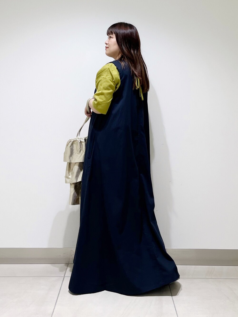 イエロー系のシャツ/ブラウス、ブルー系のワンピース、ゴールド系のトートバッグを着用したレディースの夏コーディネートの9枚目の写真