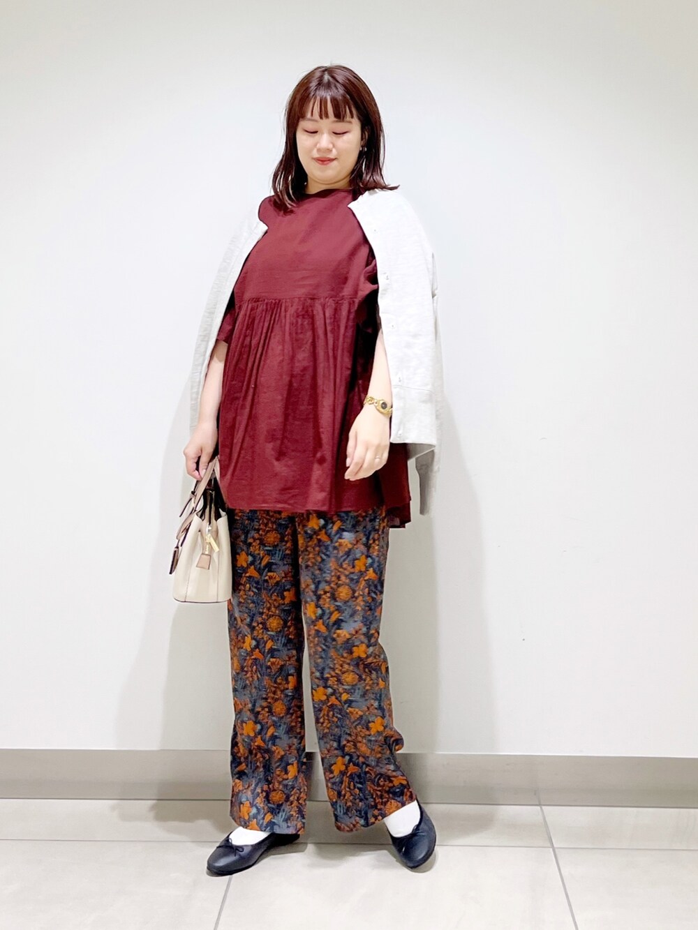 オレンジ系のその他パンツ、レッド系のシャツ/ブラウス、グレー系のカーディガン/ボレロを着用したレディースの秋コーディネートの3枚目の写真