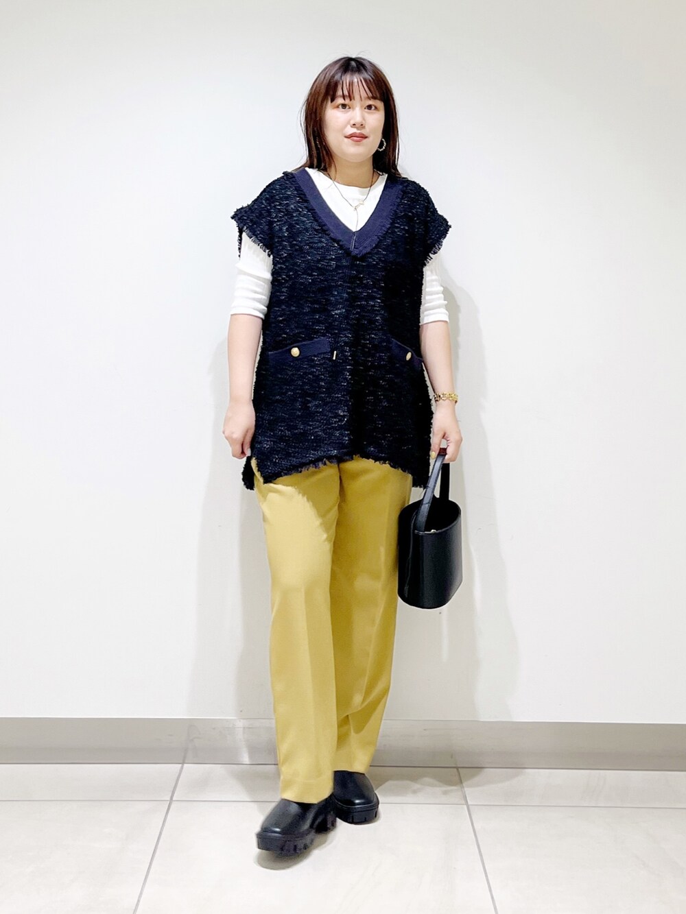 ブラック系のトップス、イエロー系のその他パンツ、ブラック系のショルダーバッグを着用したレディースの夏コーディネートの3枚目の写真