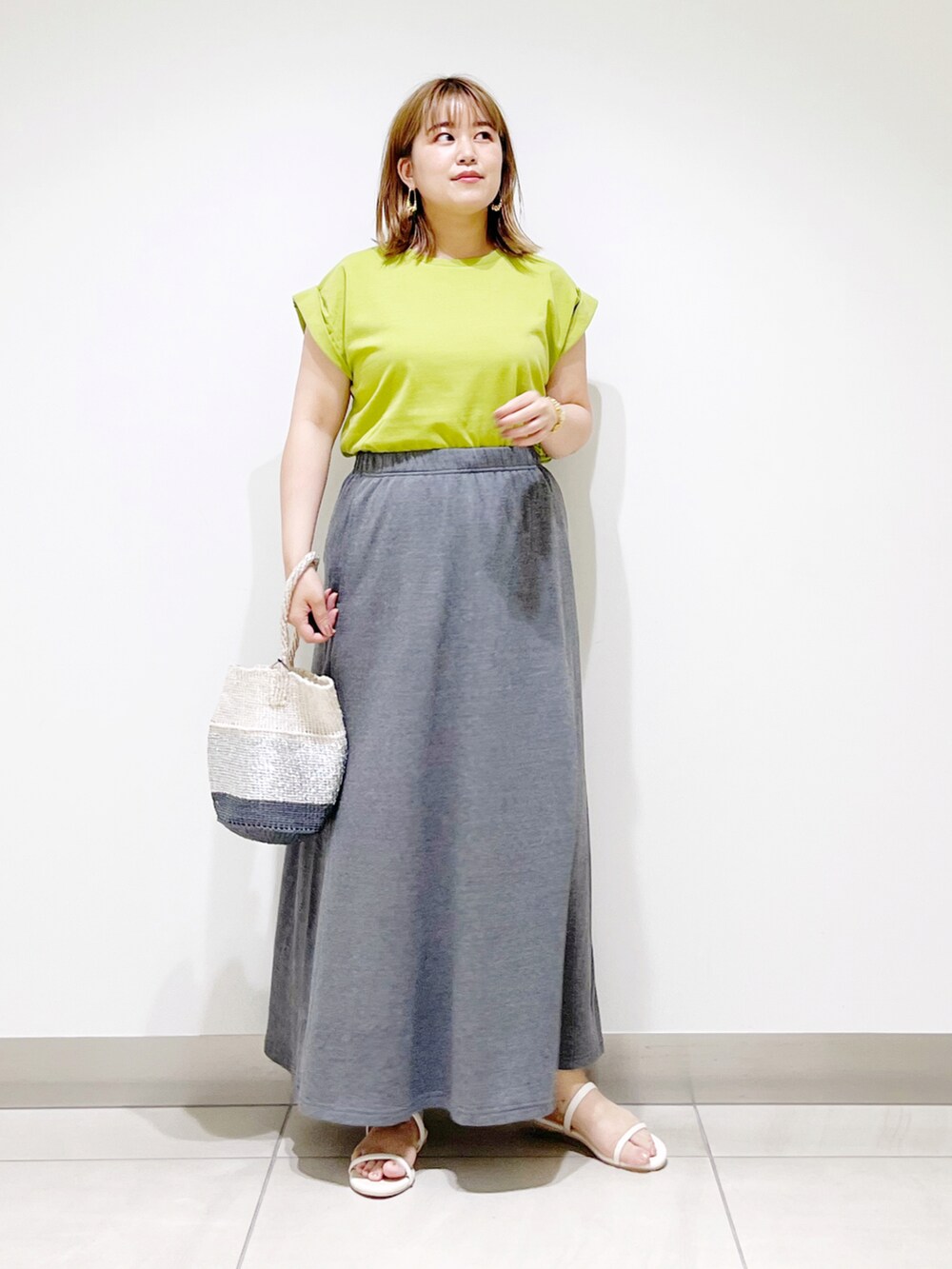 グリーン系のTシャツ/カットソー、グレー系のスカート、その他のハンドバッグを着用したレディースの夏コーディネートの5枚目の写真