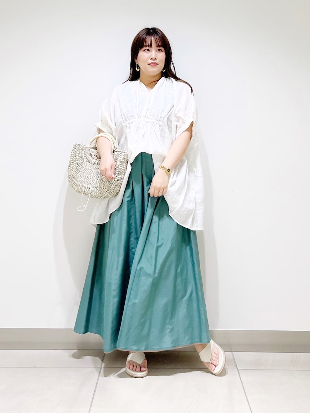 ホワイト系のシャツ/ブラウス、グリーン系のスカート、グレー系のかごバッグを着用したレディースの夏コーディネートの7枚目の写真
