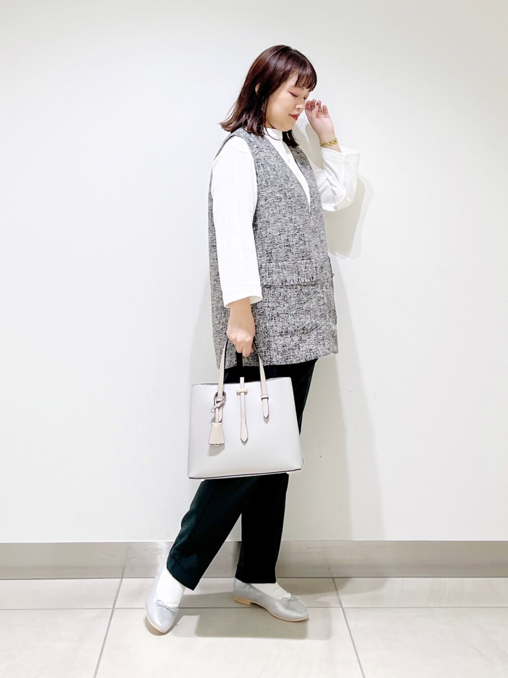 グレー系のトップス、グリーン系のパンツ、グレー系のトートバッグを着用したレディースの夏コーディネートの9枚目の写真