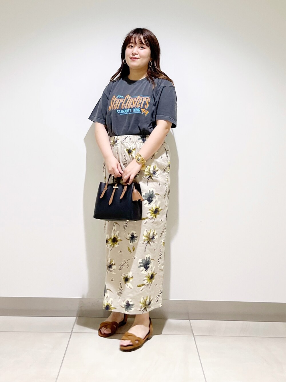 オレンジ系のTシャツ/カットソー、ブラック系のハンドバッグ、イエロー系のスカートを着用したレディースの夏コーディネートの10枚目の写真