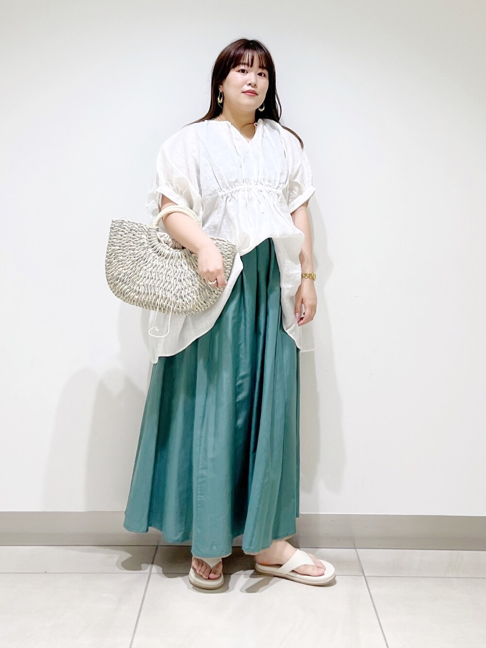ホワイト系のシャツ/ブラウス、グリーン系のスカート、グレー系のかごバッグを着用したレディースの夏コーディネートの4枚目の写真