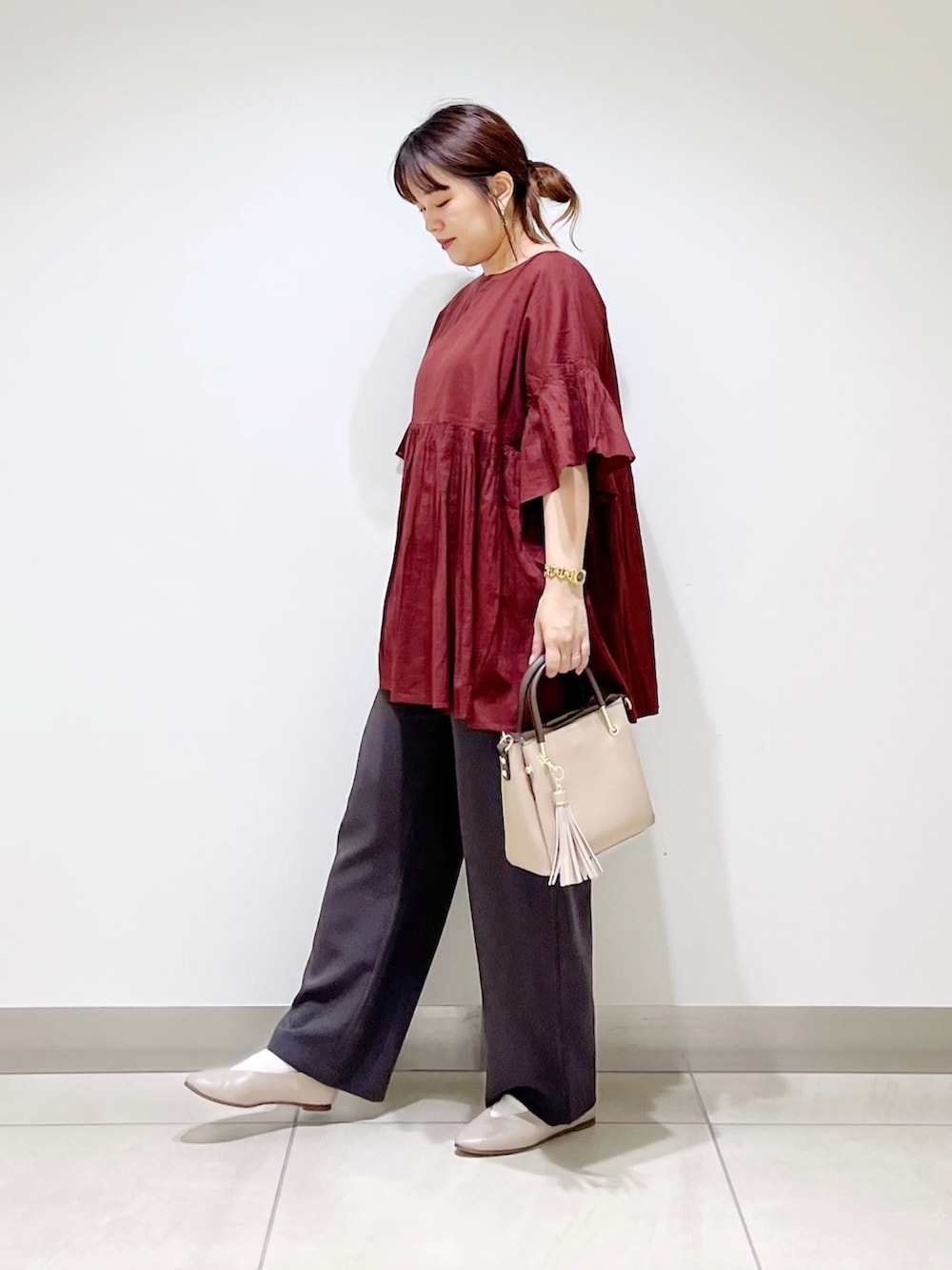レッド系のシャツ/ブラウス、グレー系のその他パンツ、ベージュ系のトートバッグを着用したレディースの夏コーディネートの6枚目の写真