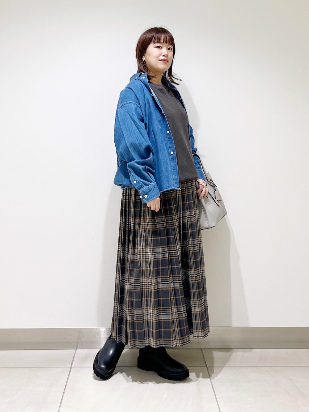 グレー系のTシャツ/カットソー、グレー系のトートバッグ、グレー系のスカートを着用したレディースの秋コーディネートの3枚目の写真