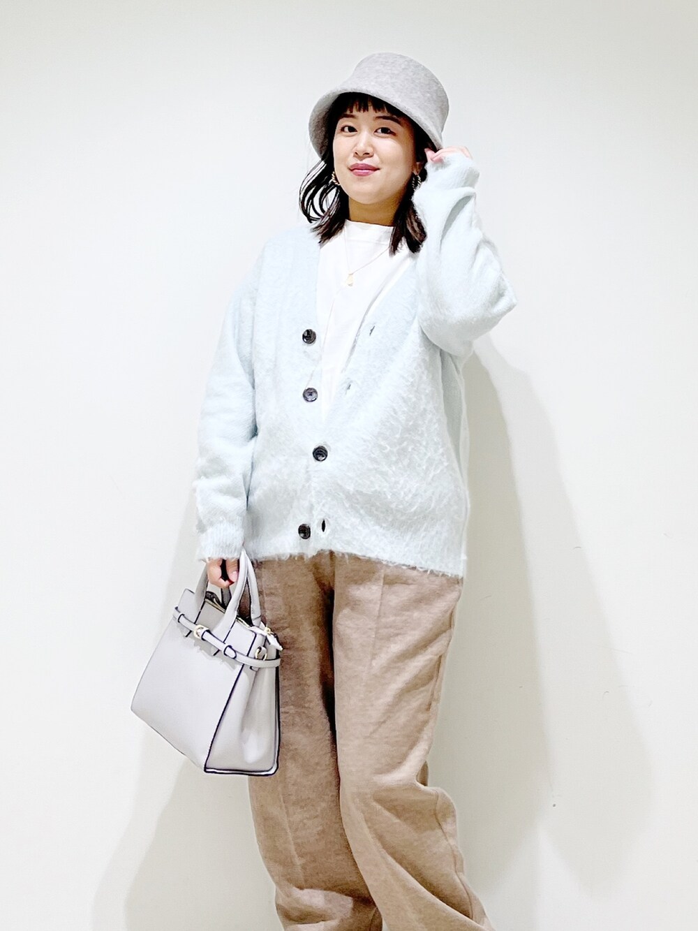 グリーン系のカーディガン/ボレロ、ベージュ系のその他パンツ、ブラック系のブーツを着用したレディースの秋コーディネートの6枚目の写真