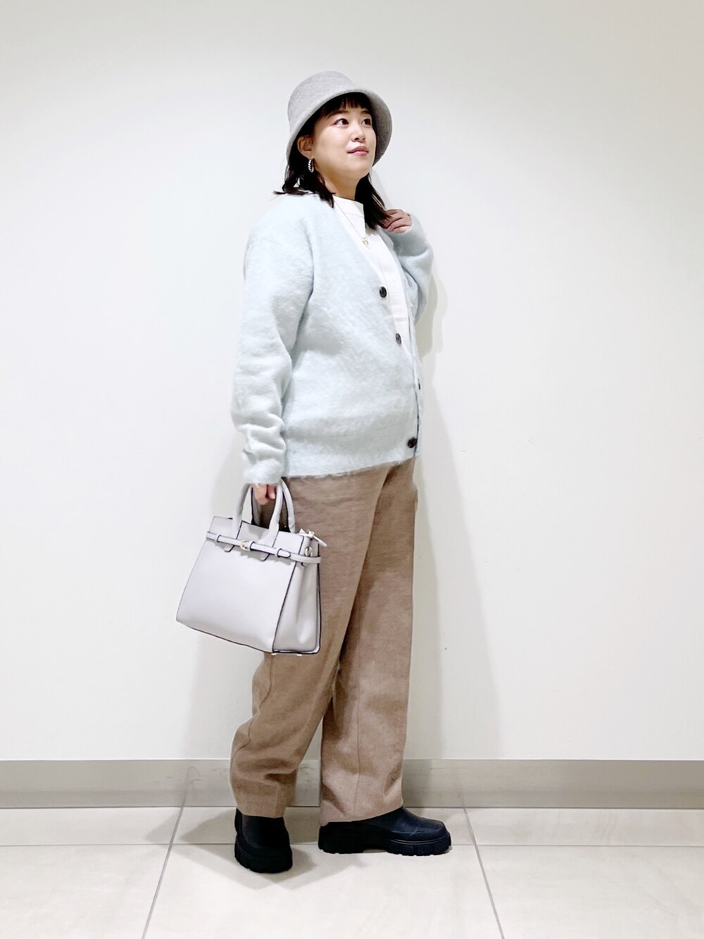 グリーン系のカーディガン/ボレロ、ベージュ系のその他パンツ、ブラック系のブーツを着用したレディースの秋コーディネートの2枚目の写真