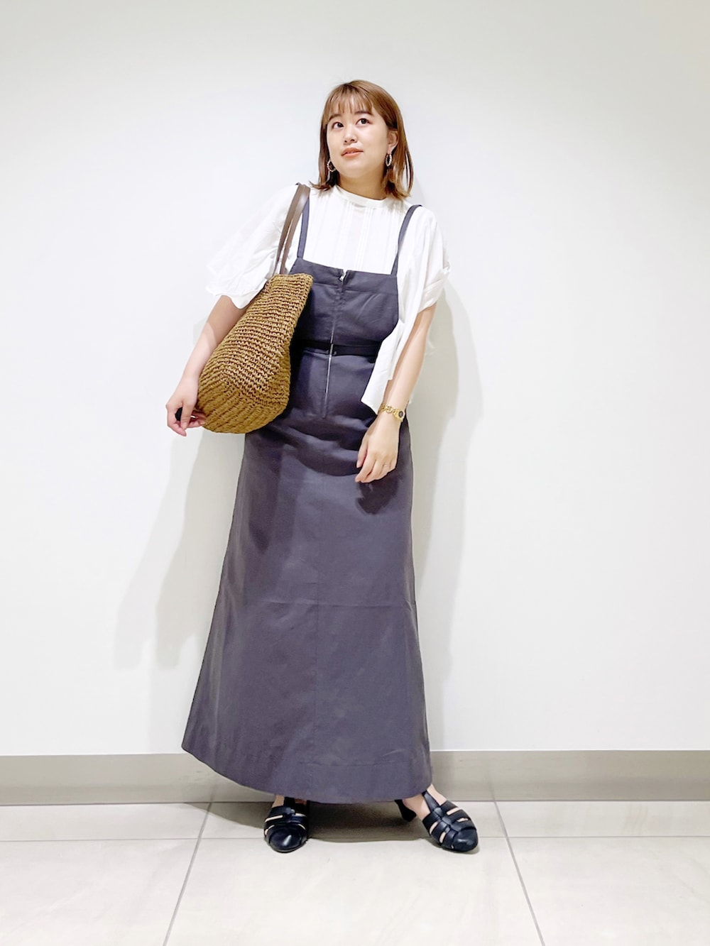 グレー系のワンピース、ホワイト系のシャツ/ブラウス、ベージュ系のトートバッグを着用したレディースの夏コーディネートの3枚目の写真