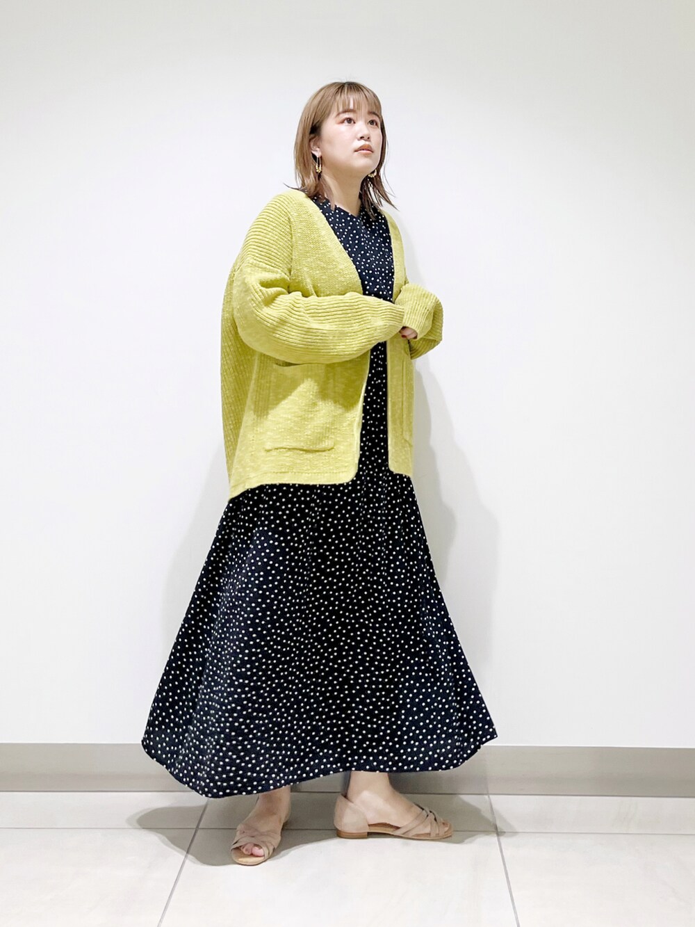 グリーン系のカーディガン/ボレロ、ブラック系のワンピース、ベージュ系のサンダルを着用したレディースの夏コーディネートの2枚目の写真